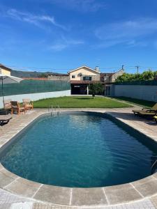 a swimming pool with blue water in a yard at Refúgio da Légua in Marco de Canaveses