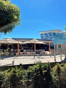 een patio met parasols en stoelen en een gebouw bij Vakantiepark Klein Vaarwater in Buren