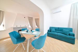 - un salon avec un canapé bleu, une table et des chaises dans l'établissement Villa Aida, à Ischia