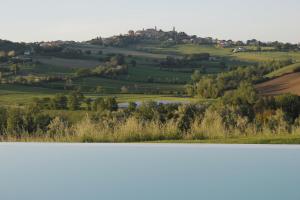 - une vue sur la vallée avec une maison sur une colline dans l'établissement Villa Edelia, à Mondavio