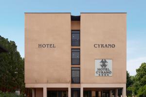 um hotel com duas placas na lateral de um edifício em Hotel Cyrano em Saronno