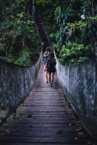 two people walking down a wooden bridge at Ritmo del Rio in San Rafael