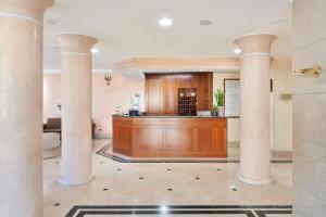 a lobby with columns and a bar in a building at Hotel Cyrano in Saronno