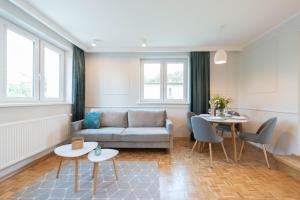 a living room with a couch and a table at Apartamenty 39 z pięknym ogrodem in Ustroń