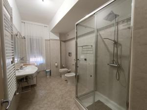uma casa de banho com um chuveiro, um lavatório e um WC. em B&B SOLE E MARE em Rossano