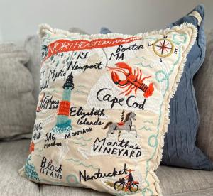 a pillow with a lighthouse on it on a couch at Modern Family Home in Middletown, RI- just 4 mi to Newport! in Middletown