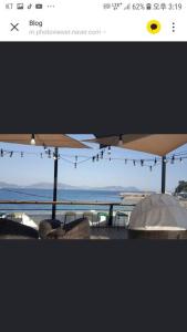 a view of the ocean from a patio with umbrellas at Private Mosageum in Yeosu