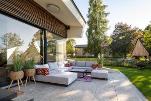 a living room with a white couch and a patio at Haus Sommerfrische in Weyregg