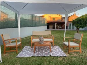 two chairs and a bench under a tent at Refúgio da Légua in Marco de Canaveses