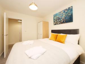 1 dormitorio con 1 cama blanca grande con almohadas amarillas en Modern&Spacious 2 Bedroom Apartment With Parking!, en Hunslet