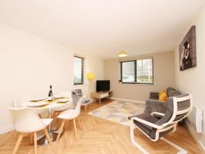 sala de estar con sofá, mesa y sillas en Modern&Spacious 2 Bedroom Apartment With Parking!, en Hunslet