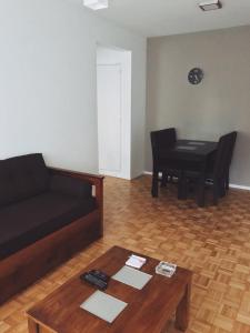 sala de estar con sofá, mesa y piano en EC Apartments en Buenos Aires