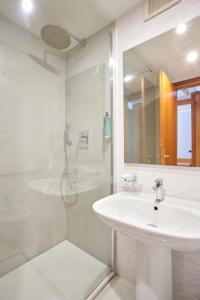 a white bathroom with a sink and a shower at Hotel Cyrano in Saronno