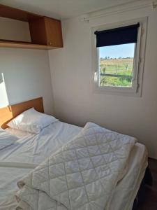 um quarto com uma cama e uma janela em Chalet Vue Mer, terrasse, nature, poney à disposition em Dieppe