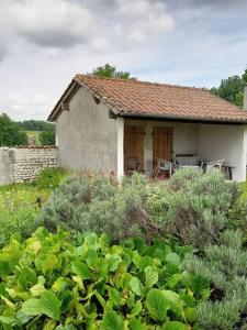 a small house with a table and chairs in a garden at Les Marronniers @ Cinq La Voûte in Ambleville