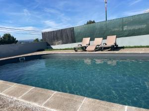 a group of chairs sitting next to a swimming pool at Refúgio da Légua in Marco de Canaveses