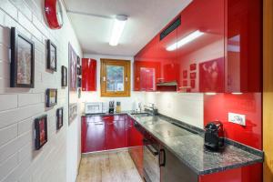 eine Küche mit roten Schränken und einer Arbeitsplatte in der Unterkunft Chalet Bergkristall in Wengen