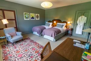 a bedroom with two beds and a table and chairs at The Kirkstyle Inn & Sportsman Rest in Brampton