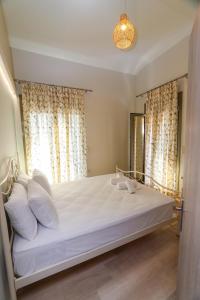 East & West Seaside Apartments في Gialtra: غرفة نوم بسرير ومخدات بيضاء ونافذة