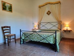 ein Schlafzimmer mit einem Bett, einem Stuhl und zwei Lampen in der Unterkunft Agriturismo le colline di Capalbio in Capalbio