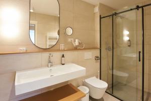 a bathroom with a sink and a toilet and a mirror at Dolcemente Garni Hotel Superior in Izola