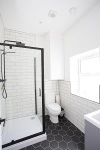 a white bathroom with a shower and a toilet at Oceans 12a Shelley Lofts, sleeps 4 in Worthing