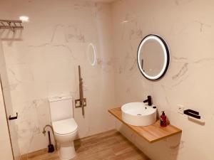 een badkamer met een toilet, een wastafel en een spiegel bij OIZPE GERNIHOST en Urdaibai in Guernica y Luno