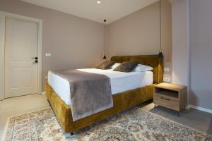 a bedroom with a large bed with a wooden frame at Dolcemente Garni Hotel Superior in Izola
