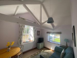 ChristowにあるKennick Barn, peace and quiet guaranteed, Dartmoorの青いソファとテーブルのあるリビングルーム