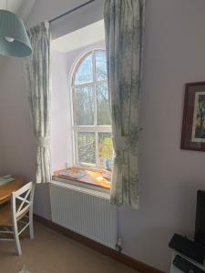 a window with curtains and a chair in a room at Kennick Barn, peace and quiet guaranteed, Dartmoor in Christow