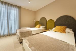 a hotel room with two beds and a window at Dolcemente Garni Hotel Superior in Izola