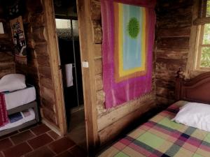 MUNAY, Posada rural para el sosiego في Alcalá: غرفة بها سرير وبطانية ملونة