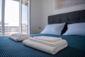 two folded towels are sitting on a bed at Aeroporto Fiumicino/Roma - Suite vista mare in Fiumicino
