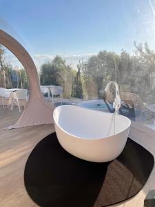 uma banheira sentada num tapete ao lado de uma janela em Tenuta Danesi & Bubble Rooms em Matera