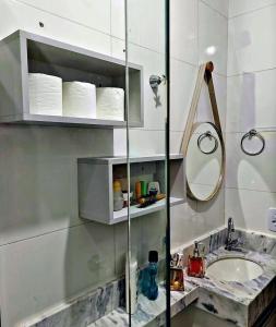 uma casa de banho com um lavatório e um espelho em Apartamento Ubatuba Maranduba 150m da Praia em Ubatuba