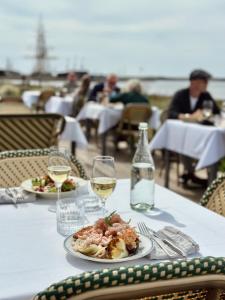 una mesa con dos platos de comida y una copa de vino en Langhoff & Juul Boutique Hotel og Restaurant en Ebeltoft