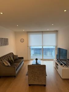 a living room with a couch and a tv at Luxurious 1 Bedroom Apartment In Croydon in Croydon
