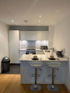 a kitchen with a counter and two bar stools at Luxurious 1 Bedroom Apartment In Croydon in Croydon