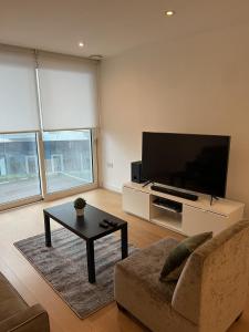 a living room with a tv and a couch and a table at Luxurious 1 Bedroom Apartment In Croydon in Croydon
