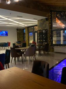 Breezy Hotel في فالبني: مطعم بطاولات وكراسي وقبو للنبيذ