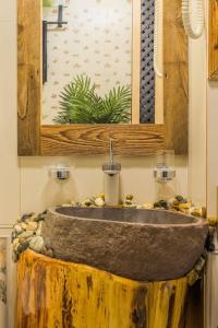 ein Badezimmer mit einem Steinwaschbecken und einem Spiegel in der Unterkunft Arthitekt I Afi Cotroceni in Bukarest