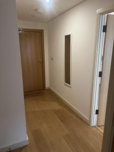 an empty room with a door and a wooden floor at Luxurious 1 Bedroom Apartment In Croydon in Croydon