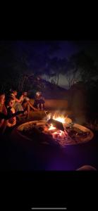 eine Gruppe von Menschen, die um eine Feuerstelle herum sitzen in der Unterkunft Ritmo del Rio in San Rafael