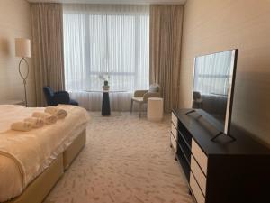 una habitación de hotel con cama y televisor de pantalla plana en Reserve Now Stylish Studio4 in Palm Tower sky pool Views, en Dubái