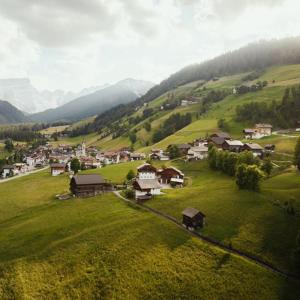 a small village on a green hill with houses at Ostí Vedl in San Martino in Badia