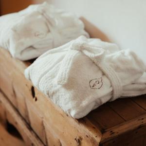 two white towels sitting on top of a wooden table at Ostí Vedl in San Martino in Badia