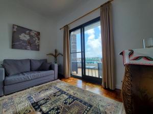 a living room with a couch and a large window at Pousada da Vila in Vila Franca do Campo