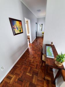 a hallway with a dining room table and wood floors at Pousada da Vila in Vila Franca do Campo