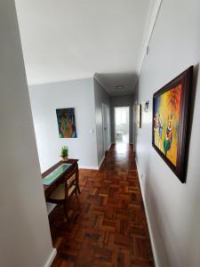 a hallway with a table and a painting on the wall at Pousada da Vila in Vila Franca do Campo