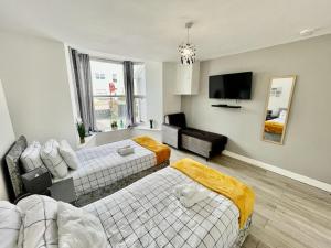 a living room with two beds and a flat screen tv at Cosy 1-Bedroom Apartment Briton Ferry, Neath Port Talbot in Briton Ferry